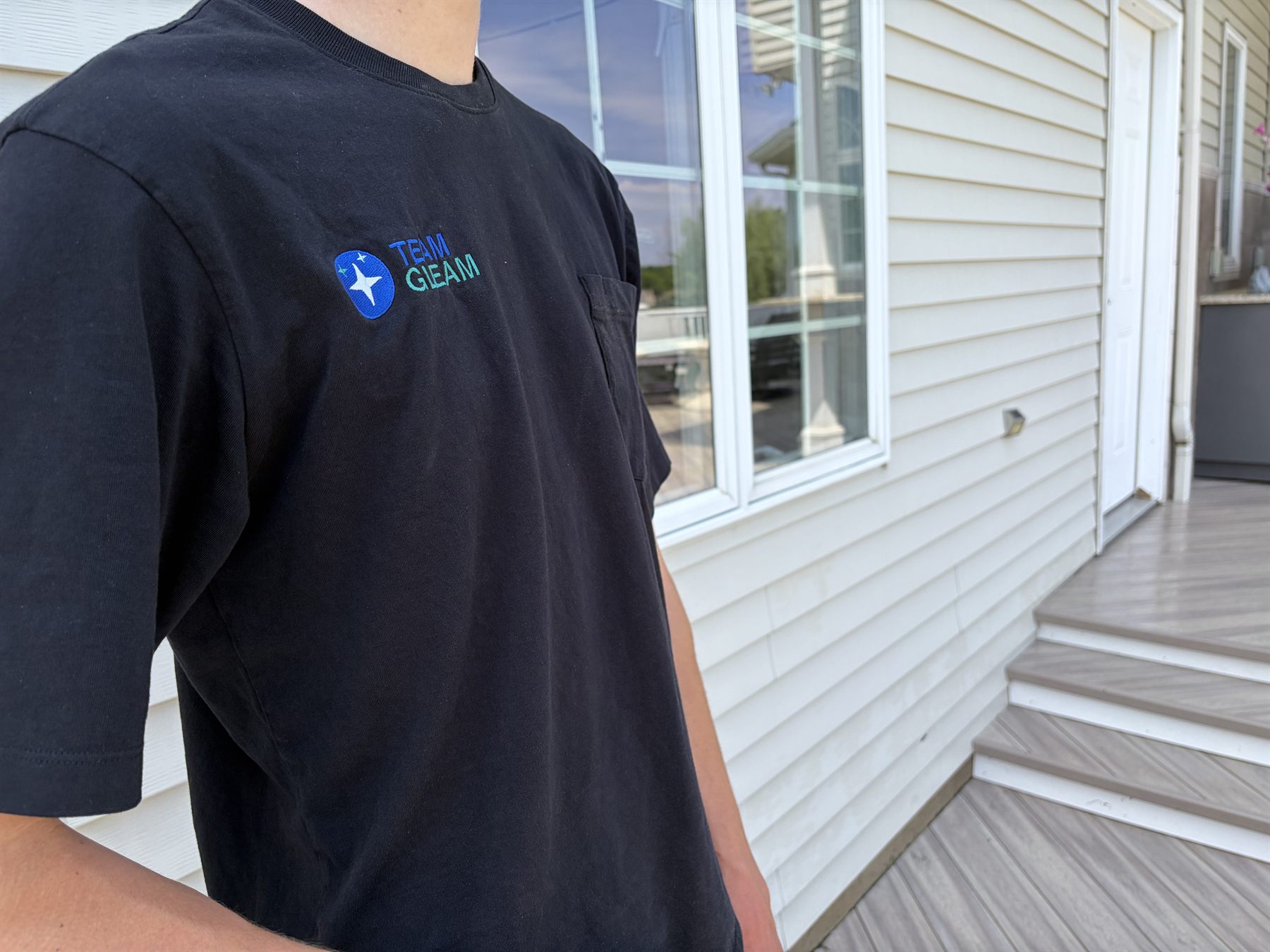 Team Gleam crew member in branded shirt on a freshly cleaned deck